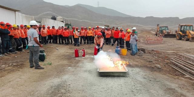Grupo de trabajadores en una práctica con fuego real en campo abierto