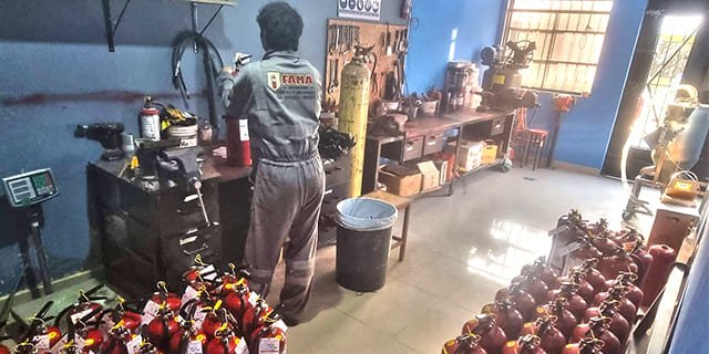 Técnico realizando la recarga de extintores en el taller